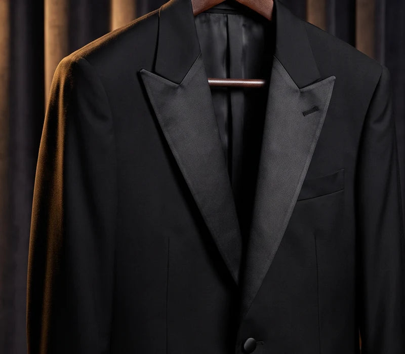 Pointed satin peak lapels on a black tuxedo jacket