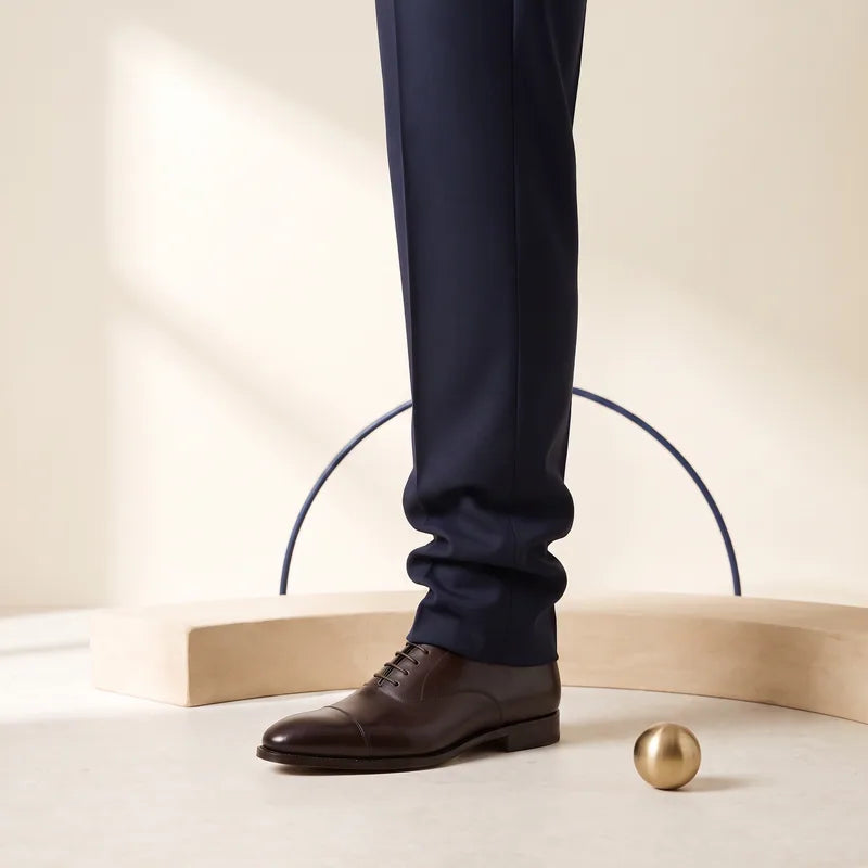 Stacked trouser hem meeting the shoe